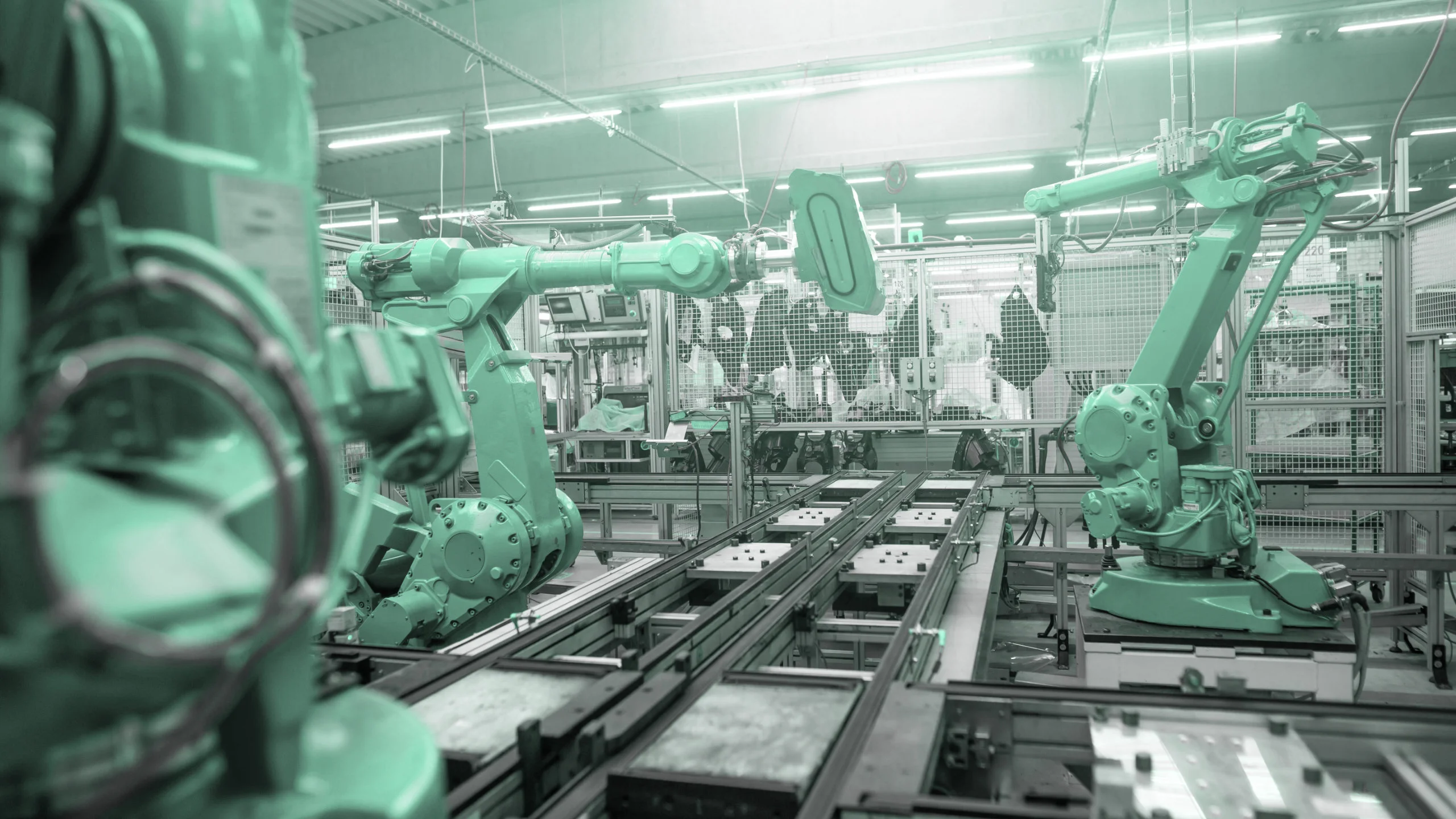 Bracci robotici industriali al lavoro su una linea di assemblaggio automatizzata in una fabbrica